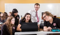 Teacher working with kids on computer