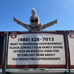 Knight mascot posing with sponsor banner